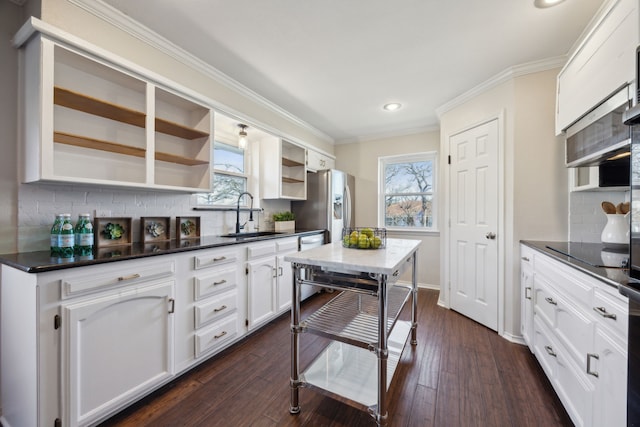 kitchen with tasteful backsplash, dark hardwood / wood-style floors, sink, stainless steel appliances, and white cabinets