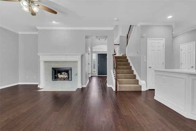 interior space with ceiling fan, dark hardwood / wood-style flooring, ornamental molding, and a premium fireplace