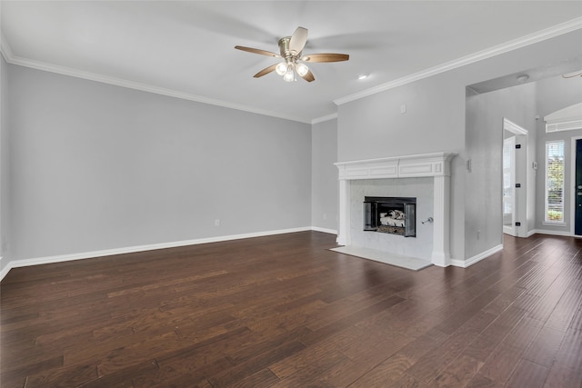 unfurnished living room with dark wood-type flooring, ceiling fan, a high end fireplace, and crown molding