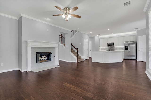 unfurnished living room featuring dark wood-type flooring, a fireplace, and ornamental molding