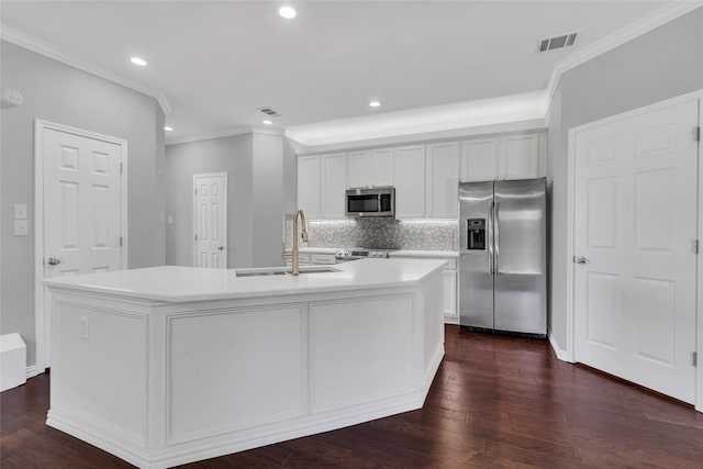 kitchen featuring stainless steel appliances, sink, white cabinetry, and an island with sink