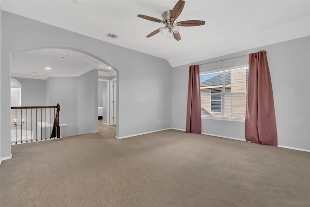 empty room with light carpet, ceiling fan, ornamental molding, and lofted ceiling