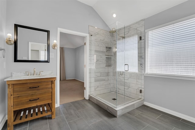 bathroom featuring vanity, vaulted ceiling, and a shower with door