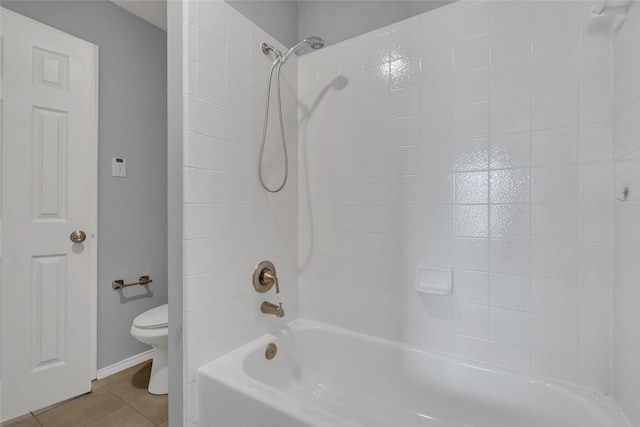 bathroom featuring tile patterned floors, toilet, and tiled shower / bath