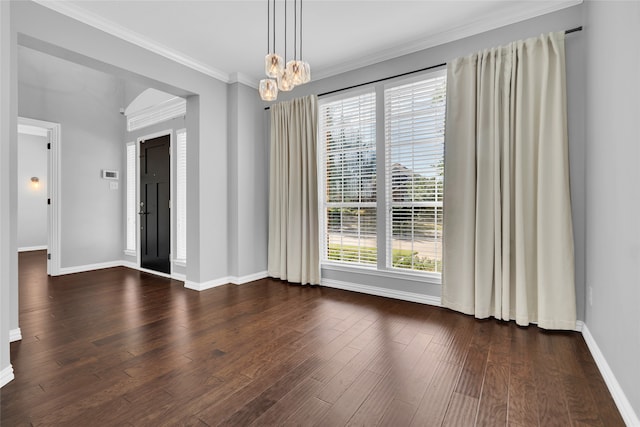 unfurnished room featuring crown molding, a healthy amount of sunlight, dark hardwood / wood-style floors, and an inviting chandelier