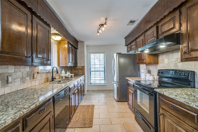 kitchen with tasteful backsplash, sink, light tile patterned floors, and black appliances