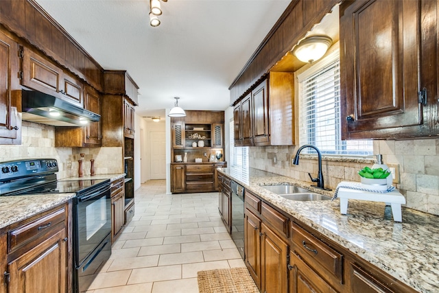 kitchen with tasteful backsplash, pendant lighting, sink, and black appliances