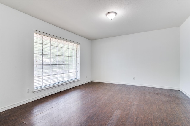 spare room with dark hardwood / wood-style floors