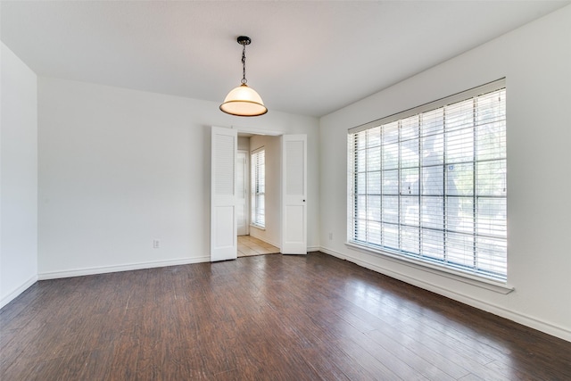 spare room with plenty of natural light and dark hardwood / wood-style floors