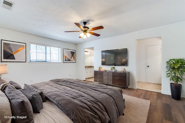 bedroom with ensuite bath, ceiling fan, and hardwood / wood-style flooring