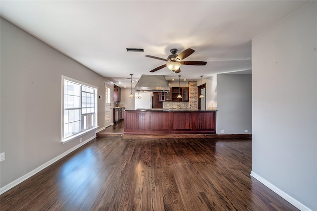 kitchen with ventilation hood, ceiling fan, decorative backsplash, decorative light fixtures, and dark wood-type flooring