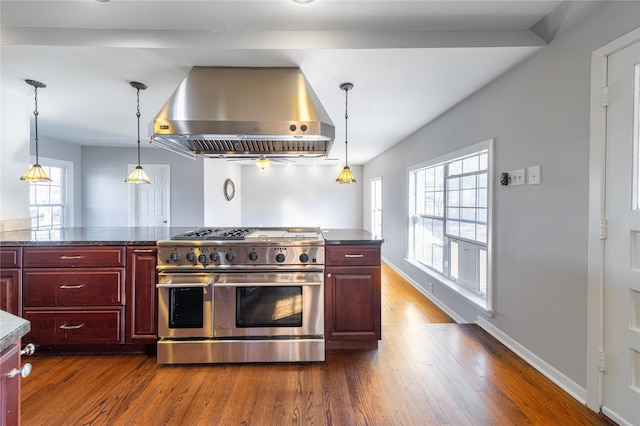 kitchen with hanging light fixtures, double oven range, dark wood-type flooring, and exhaust hood