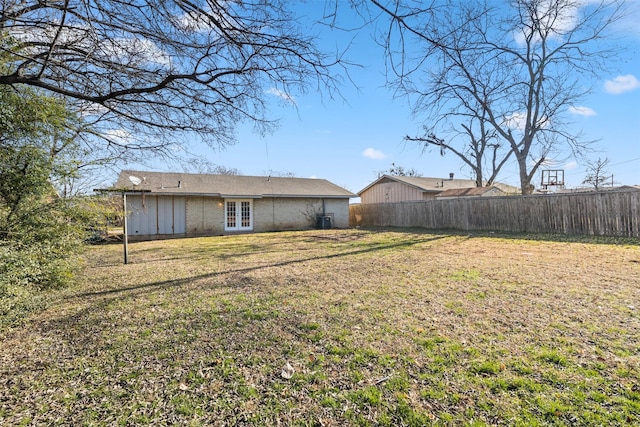 view of yard featuring central air condition unit and french doors