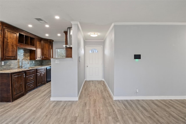 kitchen featuring tasteful backsplash, sink, crown molding, black dishwasher, and light hardwood / wood-style flooring