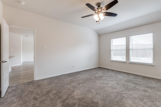 empty room with lofted ceiling, carpet floors, and ceiling fan