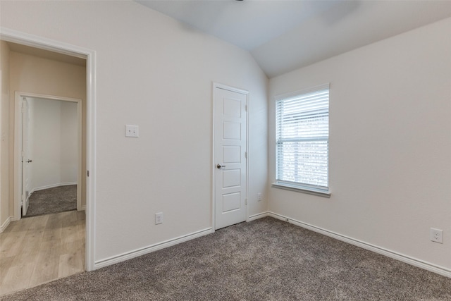 unfurnished bedroom with lofted ceiling and carpet flooring