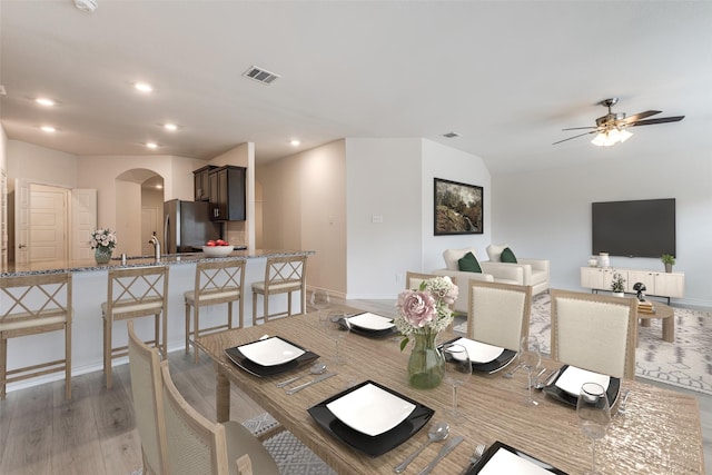 dining room with ceiling fan, sink, and light wood-type flooring