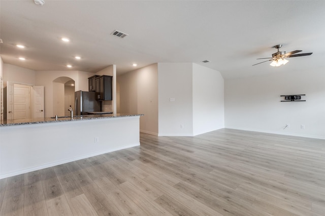 unfurnished living room featuring ceiling fan and light hardwood / wood-style flooring