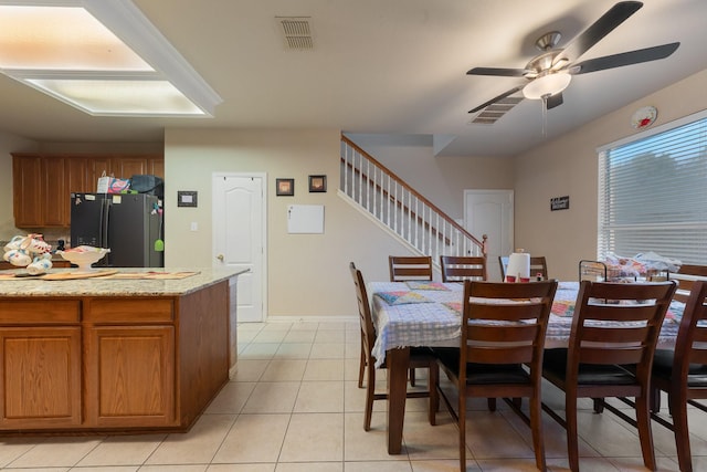 tiled dining area with ceiling fan