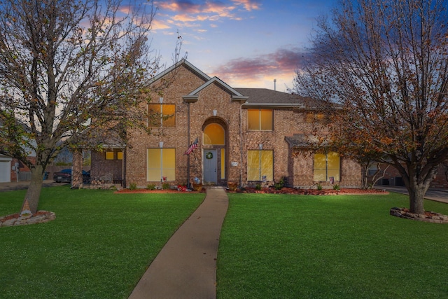 traditional-style home featuring brick siding and a front yard