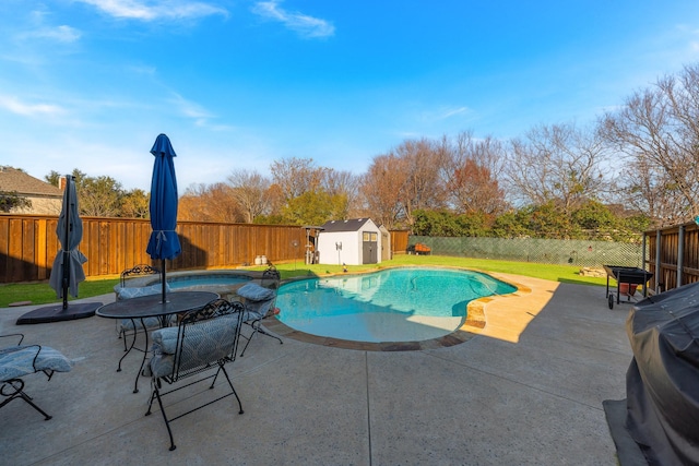 view of pool with a patio area, a storage shed, and grilling area