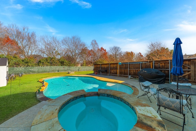 view of pool with an in ground hot tub, a yard, and a patio