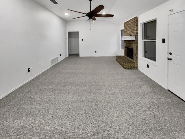 unfurnished living room with vaulted ceiling, ceiling fan, carpet, and a fireplace