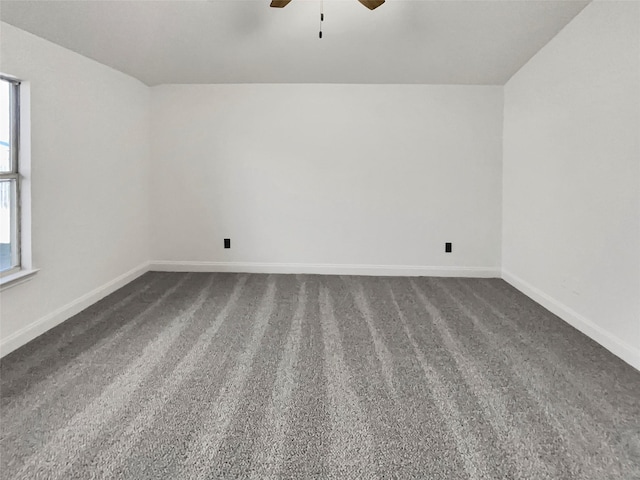 spare room featuring ceiling fan, plenty of natural light, and dark carpet