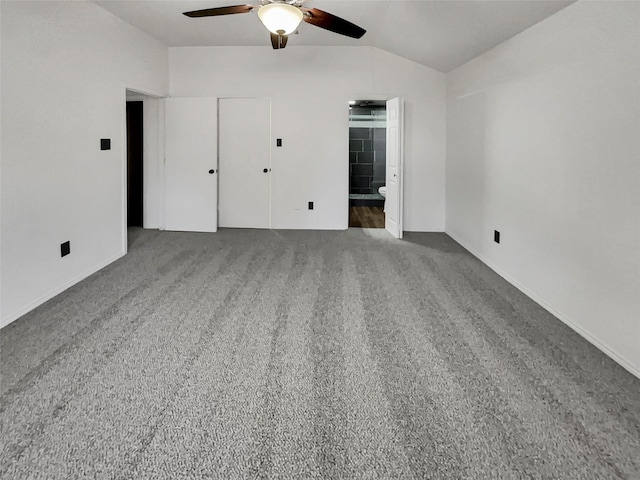 unfurnished bedroom featuring ceiling fan, ensuite bathroom, carpet floors, and vaulted ceiling