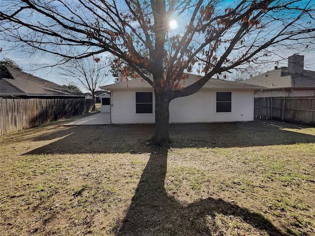 back of property featuring a lawn and a patio