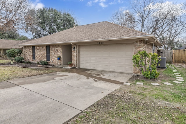 ranch-style home featuring central AC and a garage