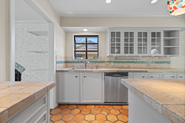 kitchen featuring backsplash, dishwasher, sink, and white cabinetry