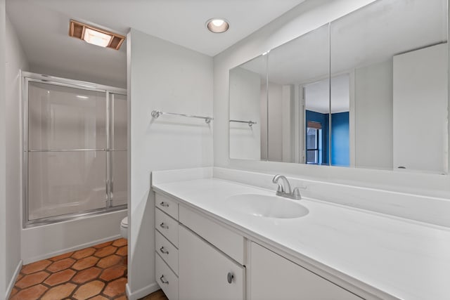 full bathroom featuring toilet, vanity, tile patterned floors, and shower / bath combination with glass door