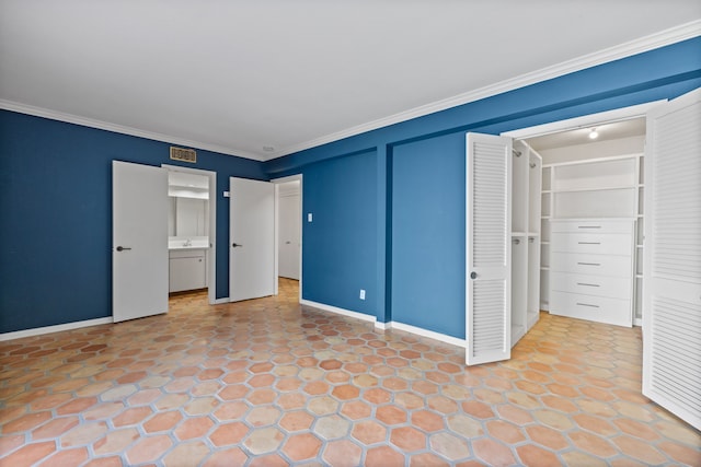 unfurnished bedroom featuring ensuite bathroom and crown molding