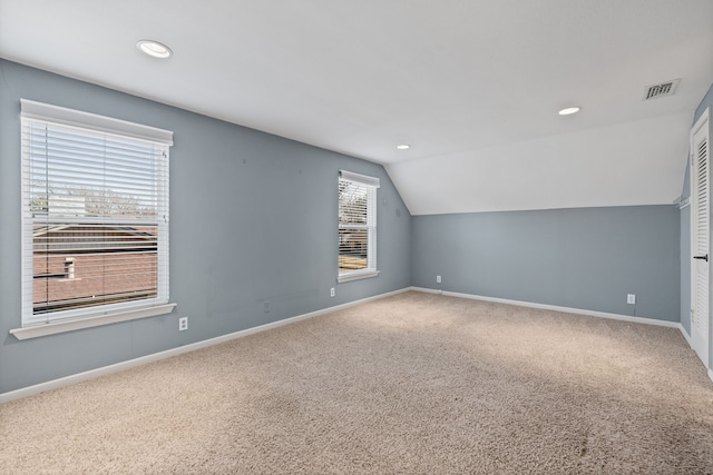 additional living space featuring carpet and lofted ceiling