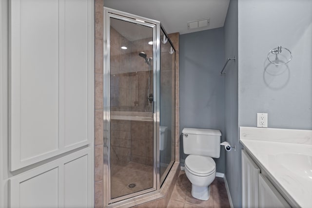 bathroom featuring tile patterned floors, walk in shower, vanity, and toilet