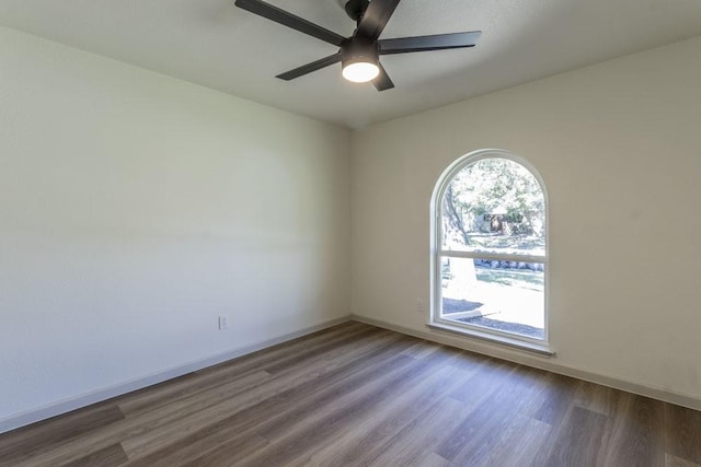 empty room with ceiling fan and dark hardwood / wood-style floors