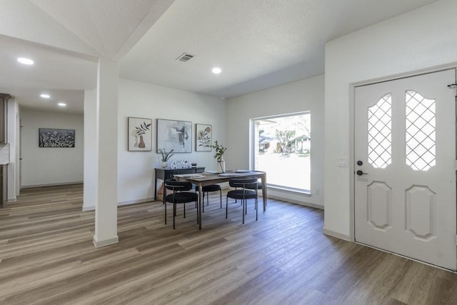 foyer with vaulted ceiling and hardwood / wood-style flooring