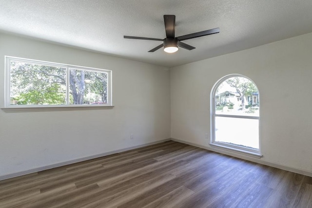 unfurnished room featuring ceiling fan, a textured ceiling, and dark hardwood / wood-style floors