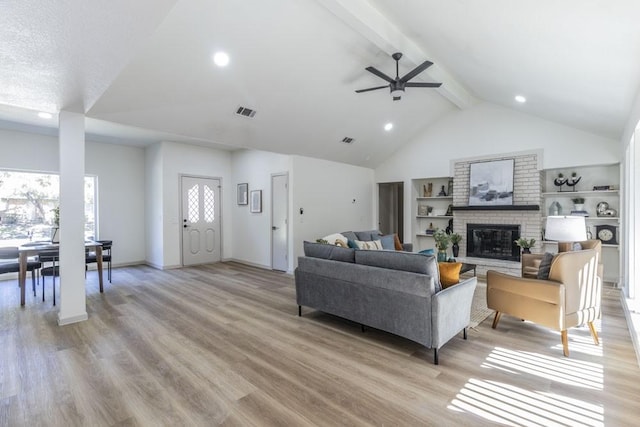 living room featuring beamed ceiling, a fireplace, light hardwood / wood-style floors, high vaulted ceiling, and ceiling fan