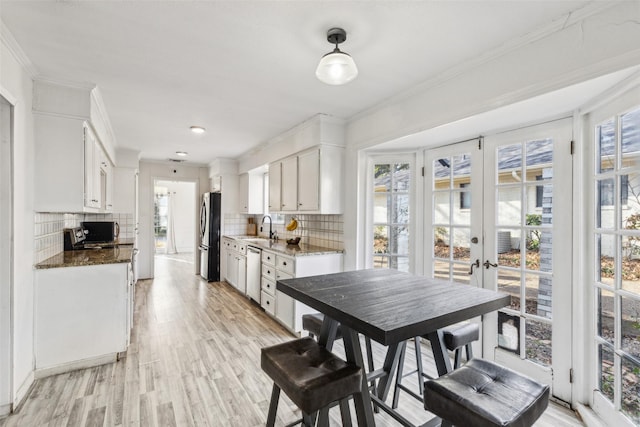 kitchen featuring white cabinetry, decorative backsplash, refrigerator, and dishwasher