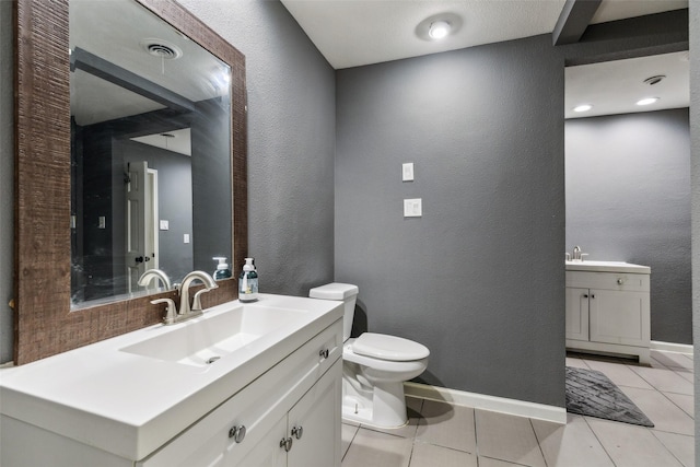 bathroom featuring toilet, tile patterned floors, and vanity