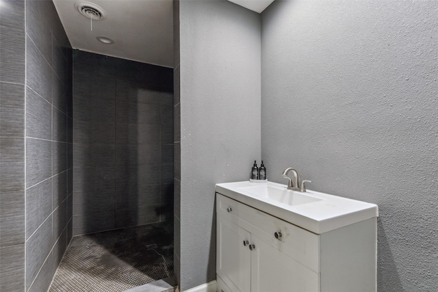 bathroom with vanity and a tile shower