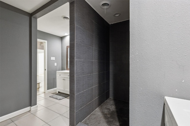 bathroom with walk in shower, vanity, and tile patterned flooring