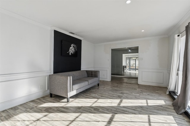 unfurnished living room featuring light hardwood / wood-style floors and crown molding