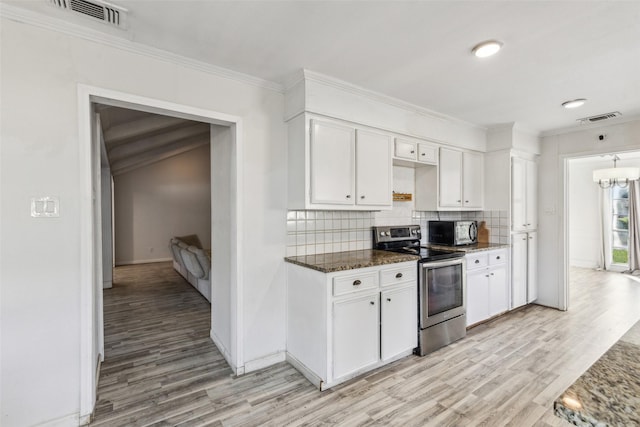 kitchen with appliances with stainless steel finishes, backsplash, white cabinetry, and dark stone counters