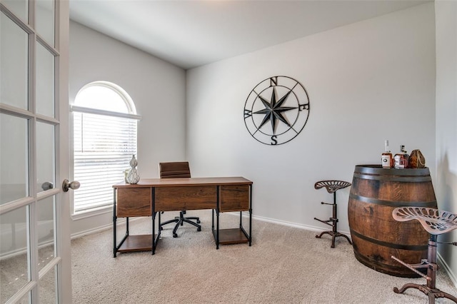 carpeted office space with lofted ceiling and french doors