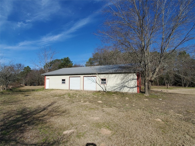 view of outdoor structure featuring a garage and a lawn