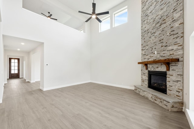 1233 Sylvia St, Desoto, TX 75115 - unfurnished living room featuring a ceiling fan, a towering ceiling, wood finished floors, baseboards, and a fireplace