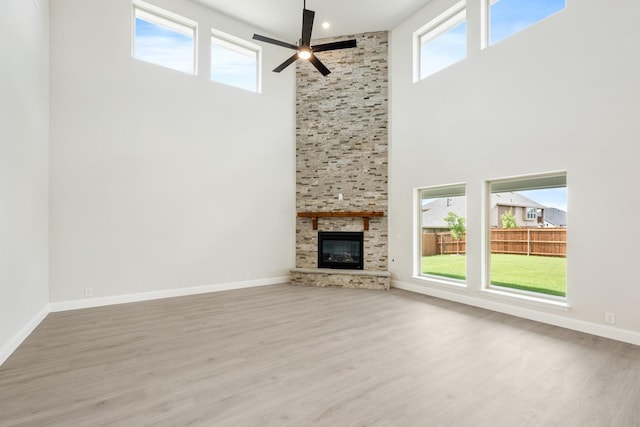 1233 Sylvia St, Desoto, TX 75115 - unfurnished living room with a high ceiling, wood finished floors, a ceiling fan, a fireplace, and baseboards